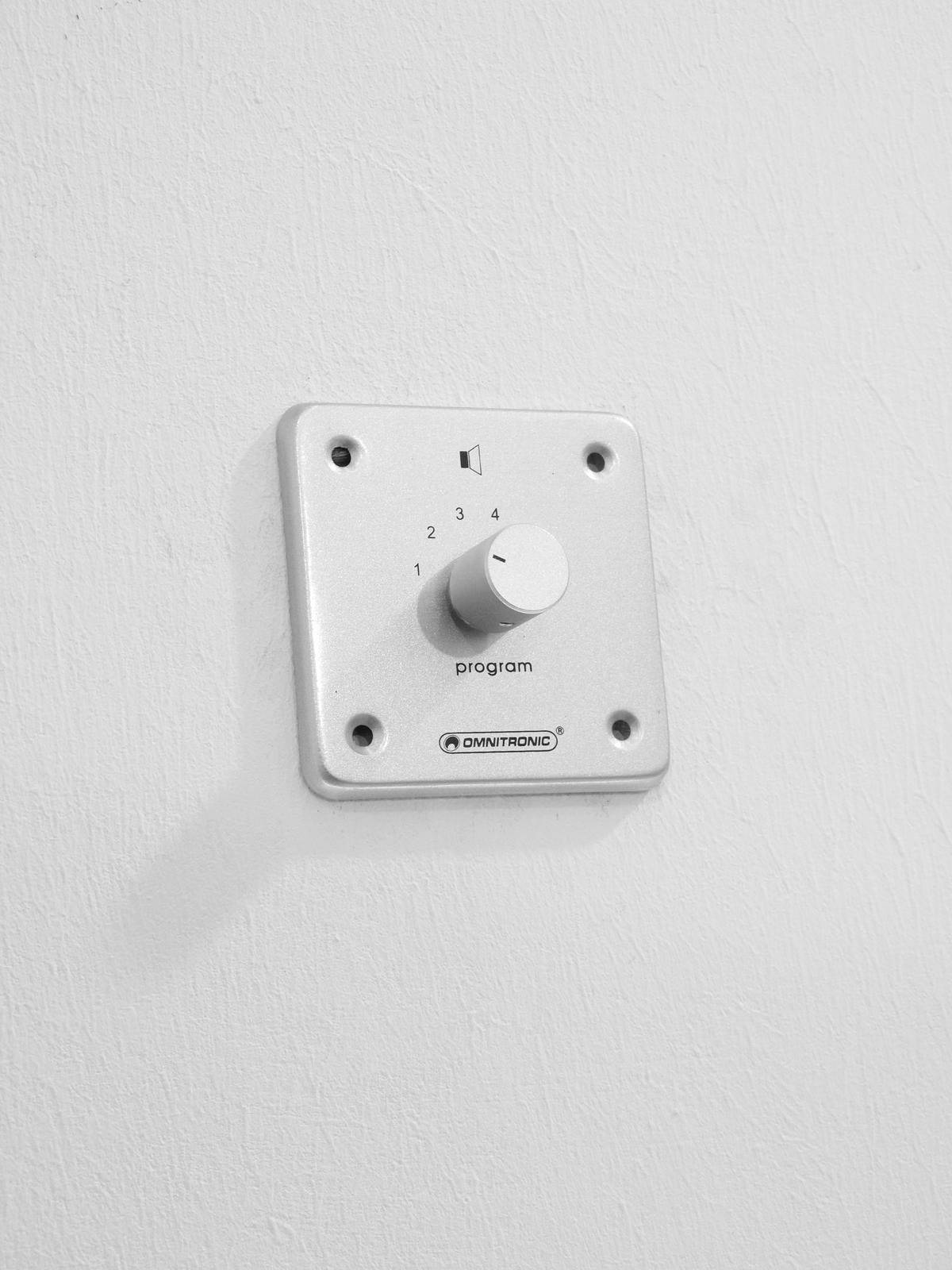 A silver rotary dial on the wall with numbers from 1 to 4 and the label 'Programme' underneath.
