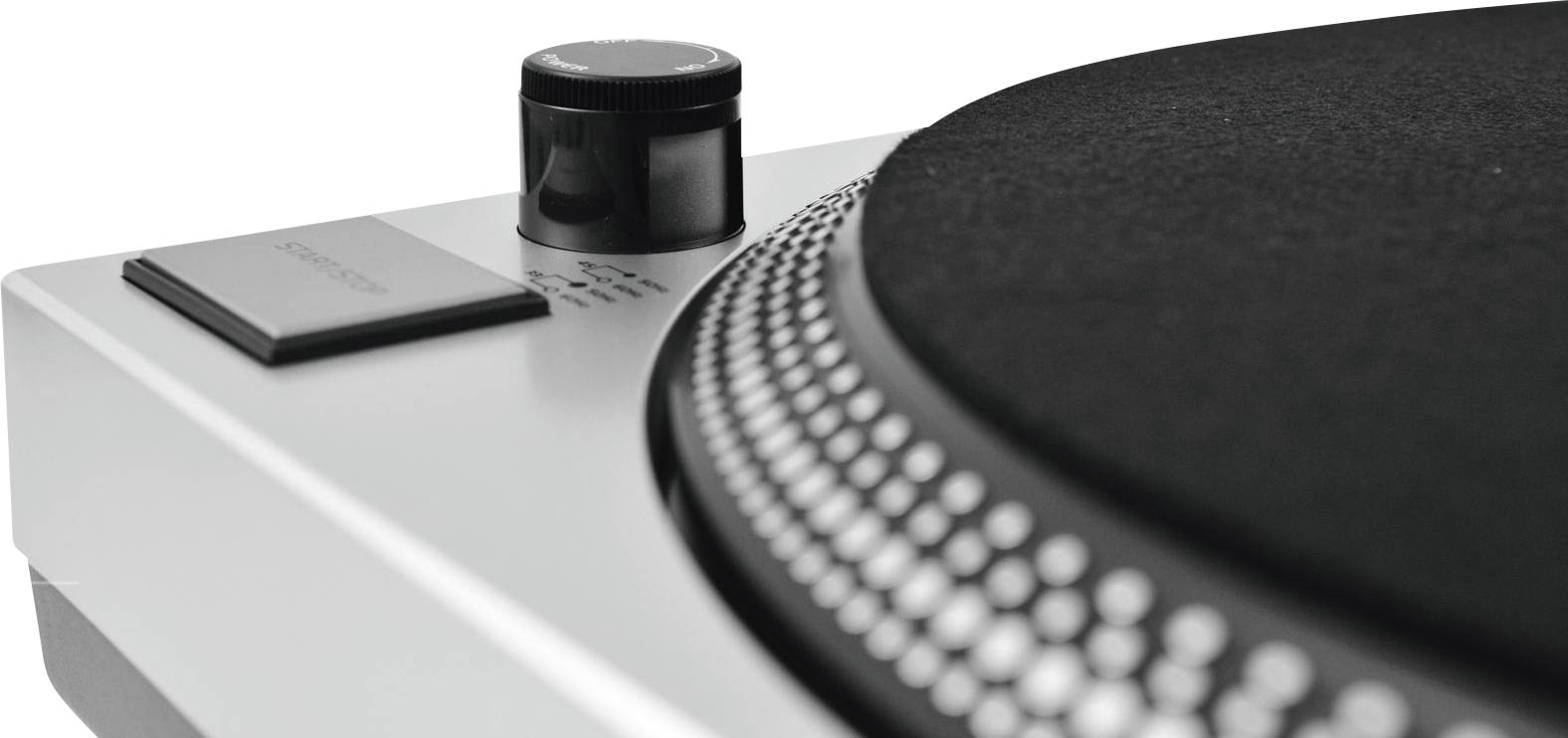 Record player in close-up, showing the edge of a black turntable with typical markings and a rotary control dial.