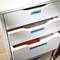 A white cabinet with three open drawers, labelled 'Files', 'Invoices' and 'Office Supplies', filled with documents and office materials.