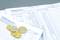 A cash book with handwritten numbers and a cash report lies on a table. Next to it are euro coins and a pen.