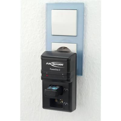 A charger by Ansmann is plugged into a wall socket and is charging a battery.