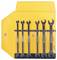 A set of seven open-end wrenches in sizes ranging from 3.5 to 10 mm, neatly organized in a yellow plastic holder, mounted on a wall.
