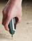 A hand holds an electric screwdriver from a well-known brand and drives a screw into a wooden board.