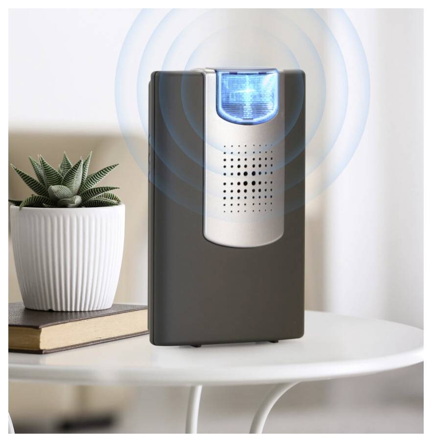 'A plug-in pest repeller emits ultrasonic waves, indicated by blue waves, on a white table next to a small potted plant.'