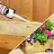 A hand is using Ponal Construction adhesive to repair a wooden box with colourful flowers. The background features a wooden panelling.