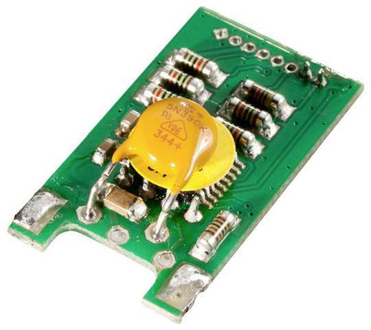 A green circuit board with resistors and a yellow circular capacitor mounted on it. The board appears designed for electronic connections.