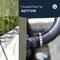 A close-up of a hose with a mounted clamp. Plants in the background. Text reads 'HoseClamp ACTIVE' with a circular logo.
