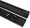 Two black plastic grilles with longitudinal slits and textured edges, lying side by side on a white surface.