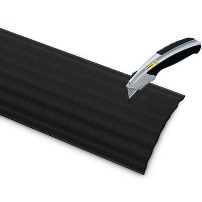 Black wave-patterned plastic material being cut with a silver craft knife.
