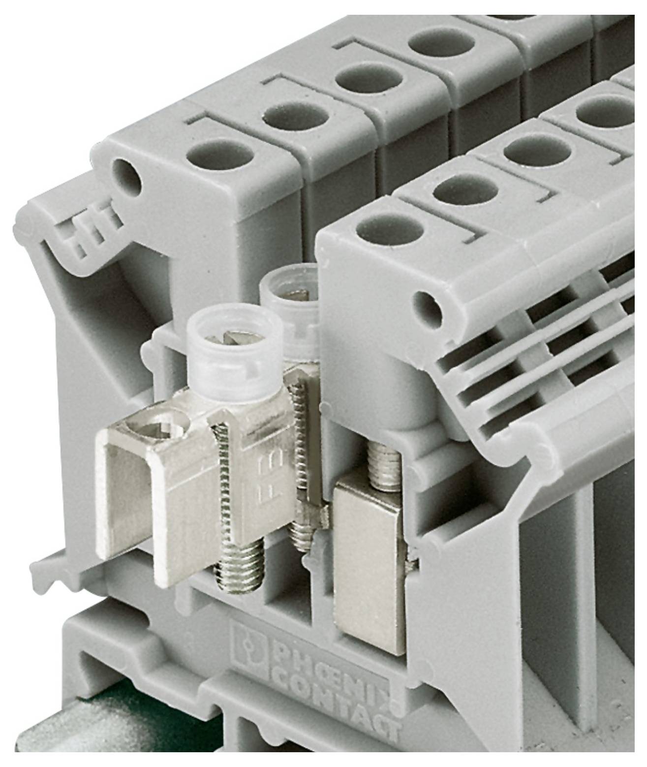 A gray electrical terminal block with wiring slots and a metal clamp, used for securing and connecting electrical wires.