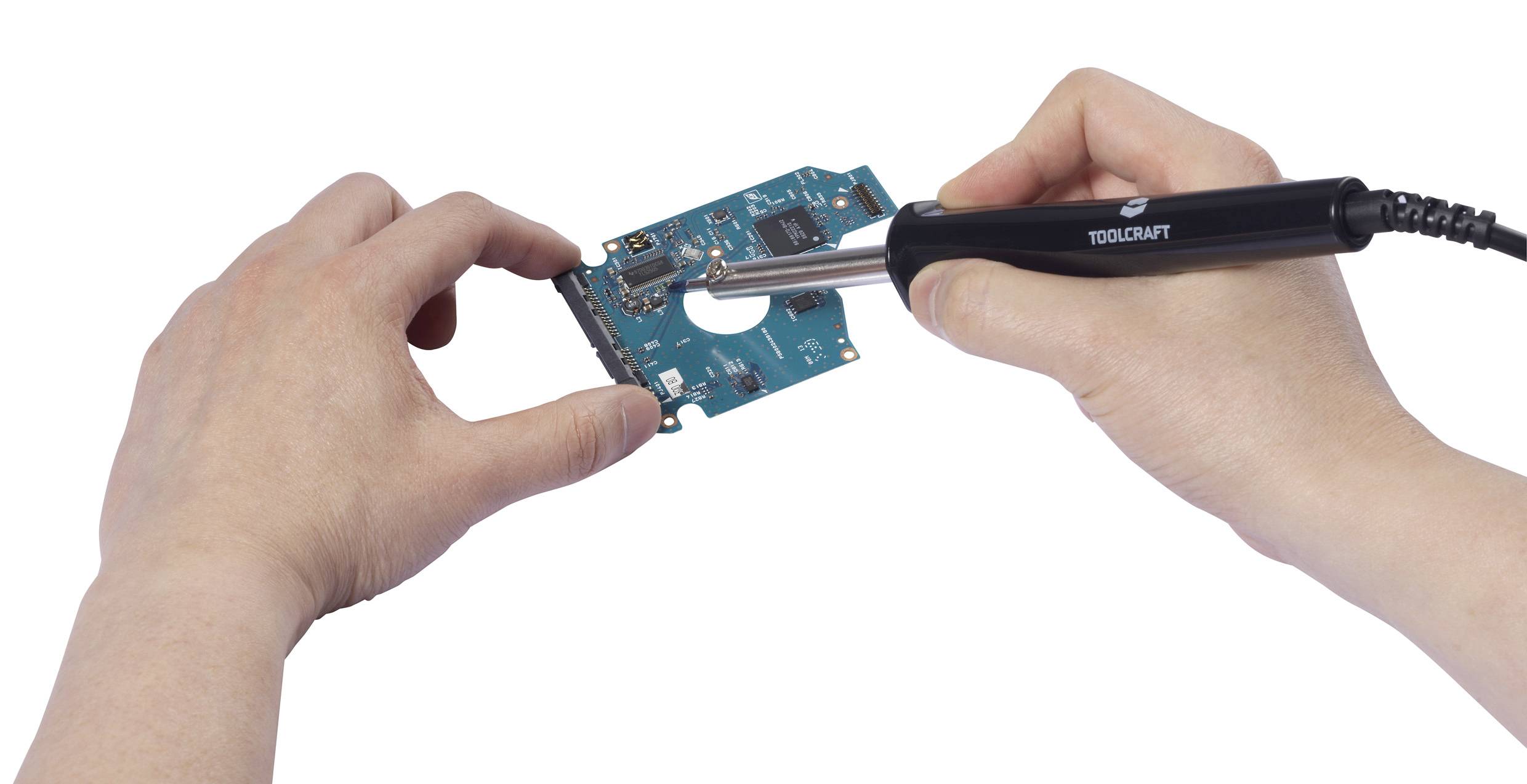 A person is soldering with a soldering iron on a blue circuit board held in their other hand.