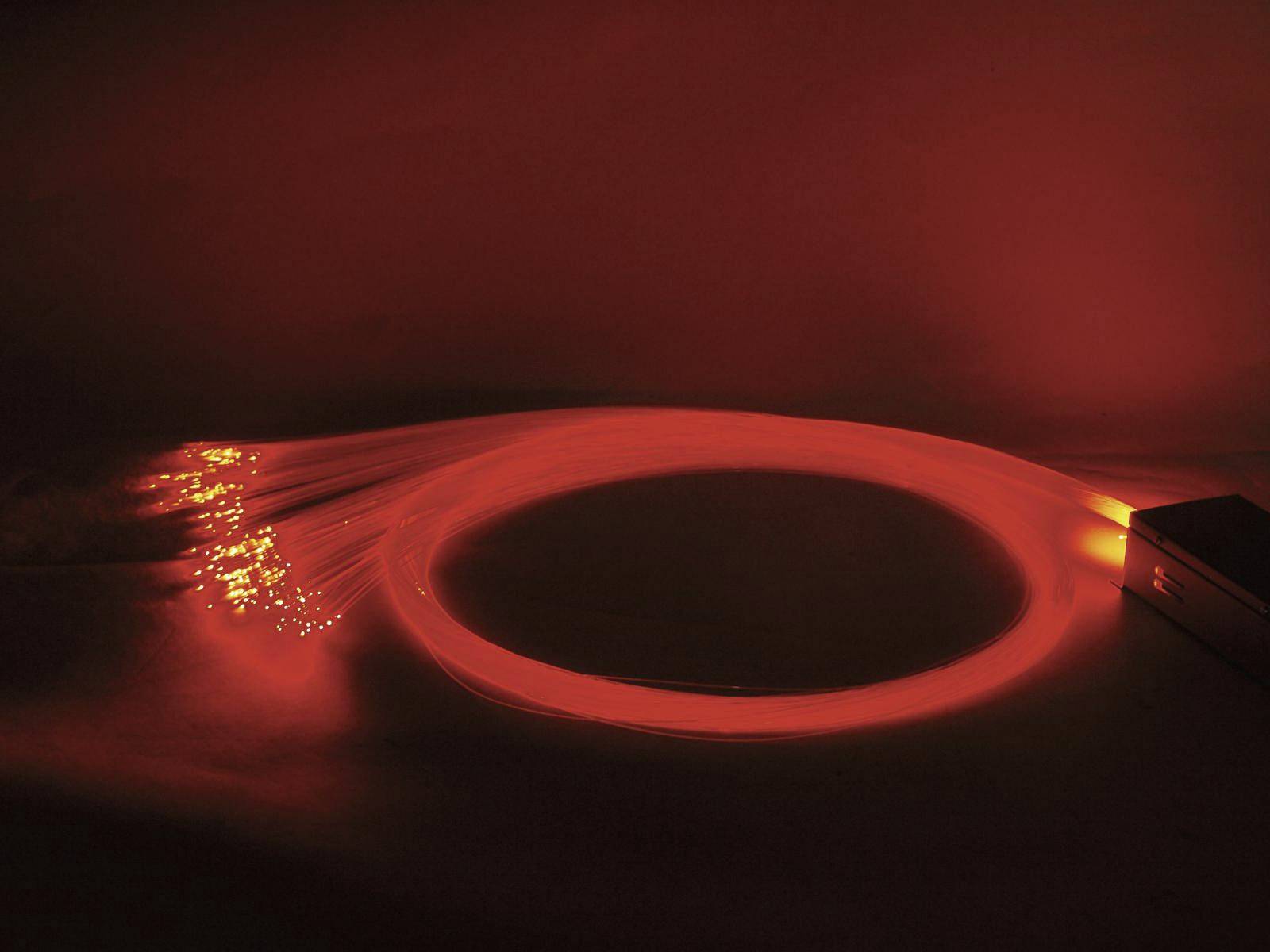 Luminous fibre optic cables emitting orange-red light symbolise rapid data transmission or modern technology.
