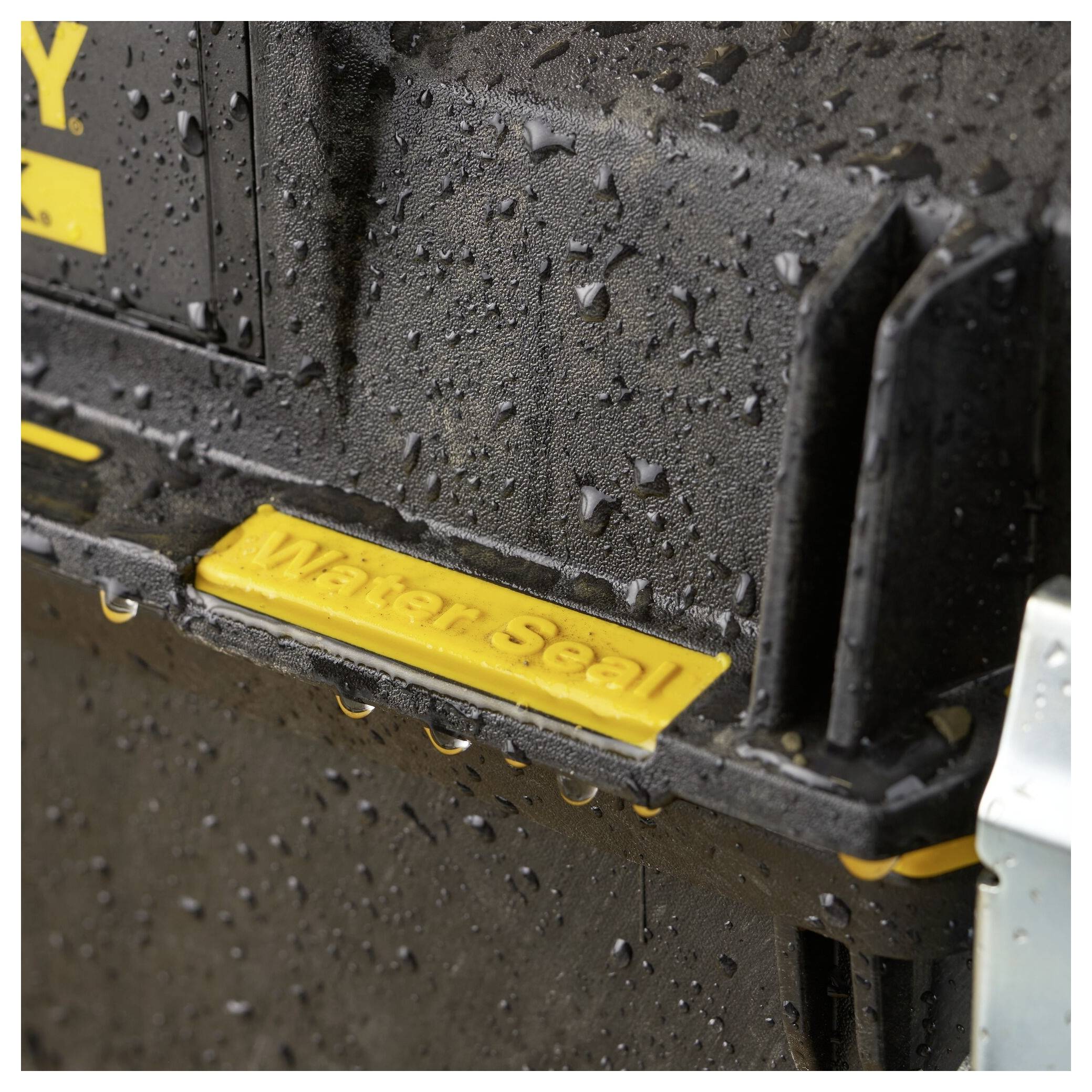 Close-up of a wet, black tool box with a yellow inscription 'Water Seal', indicating water resistance.