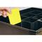 A hand is placing a yellow divider into a black compartmentalised box with multiple sections.