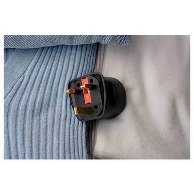 Black UK three-pin plug resting on a blue and gray ribbed fabric surface.<br>