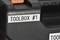 Black toolbox with a label reading 'TOOLBOX #1'. An orange handle is visible in the top left corner.