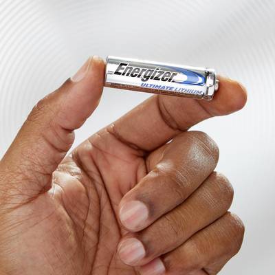 A hand is holding a silver AA battery with the inscription 'Energizer Ultimate Lithium' against a neutral background.