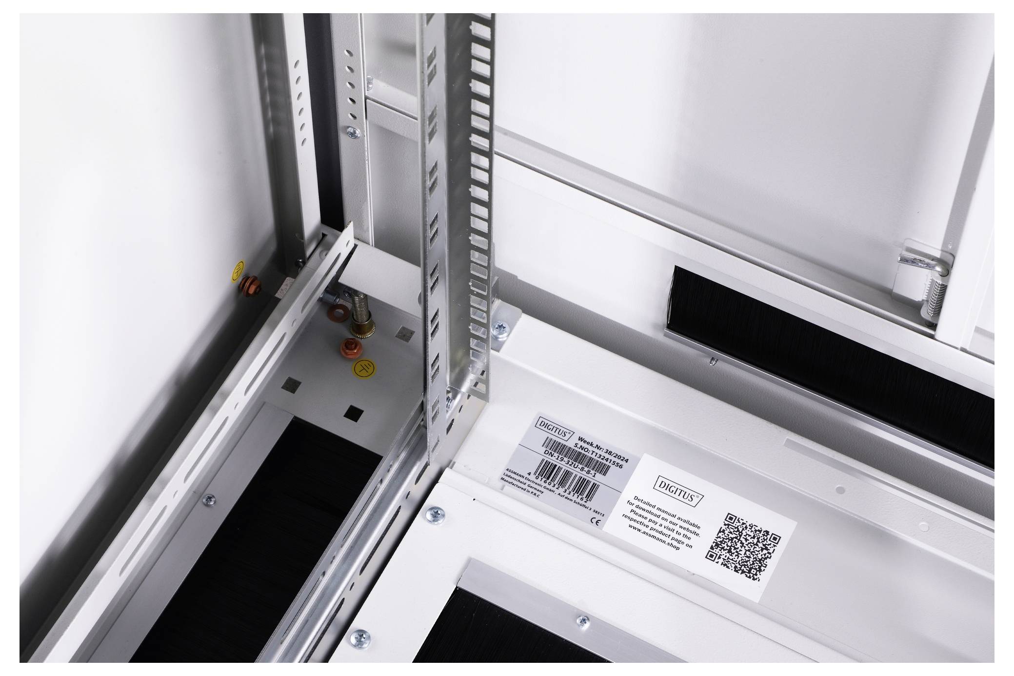 Interior view of an electrical cabinet with cable management system, labels and QR code visible; shows detail of the construction.