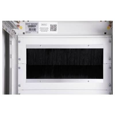 'White industrial wall with a rectangular ventilation grille. Above it, a QR code and label with technical information and barcode.'