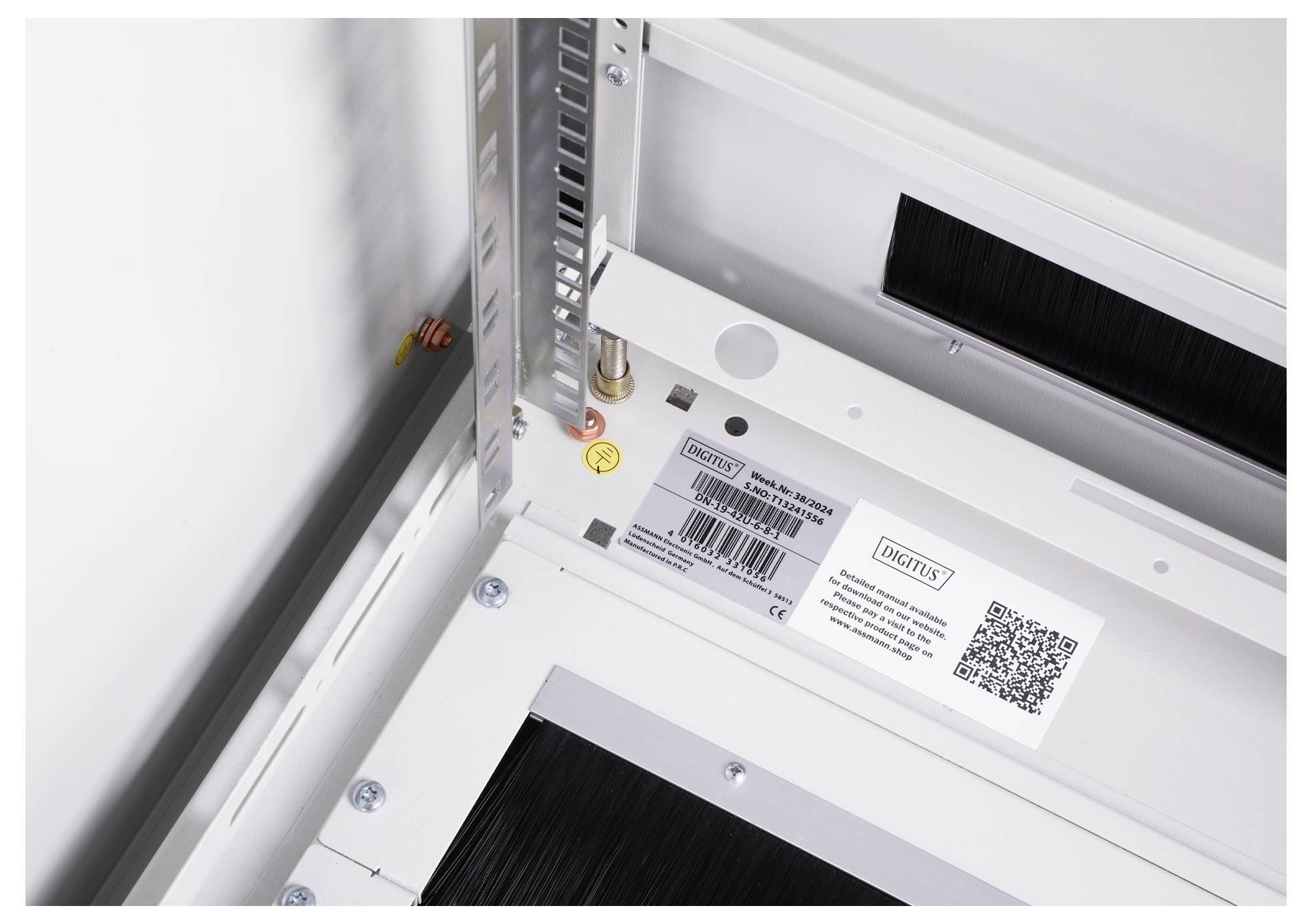 Metal structure with QR code sticker and screw. Rectangular space shows technical details. The focus is on the labelling.