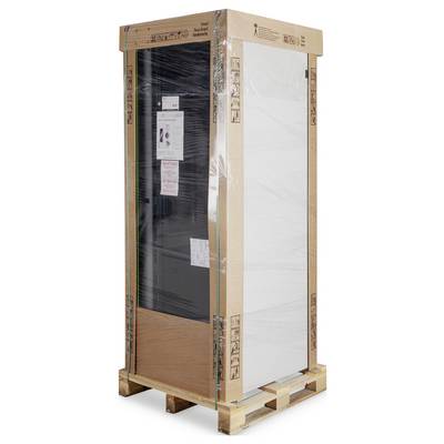 A large, packaged wardrobe stands on a wooden pallet. The wardrobe is wrapped in film and has cardboard around its edges.