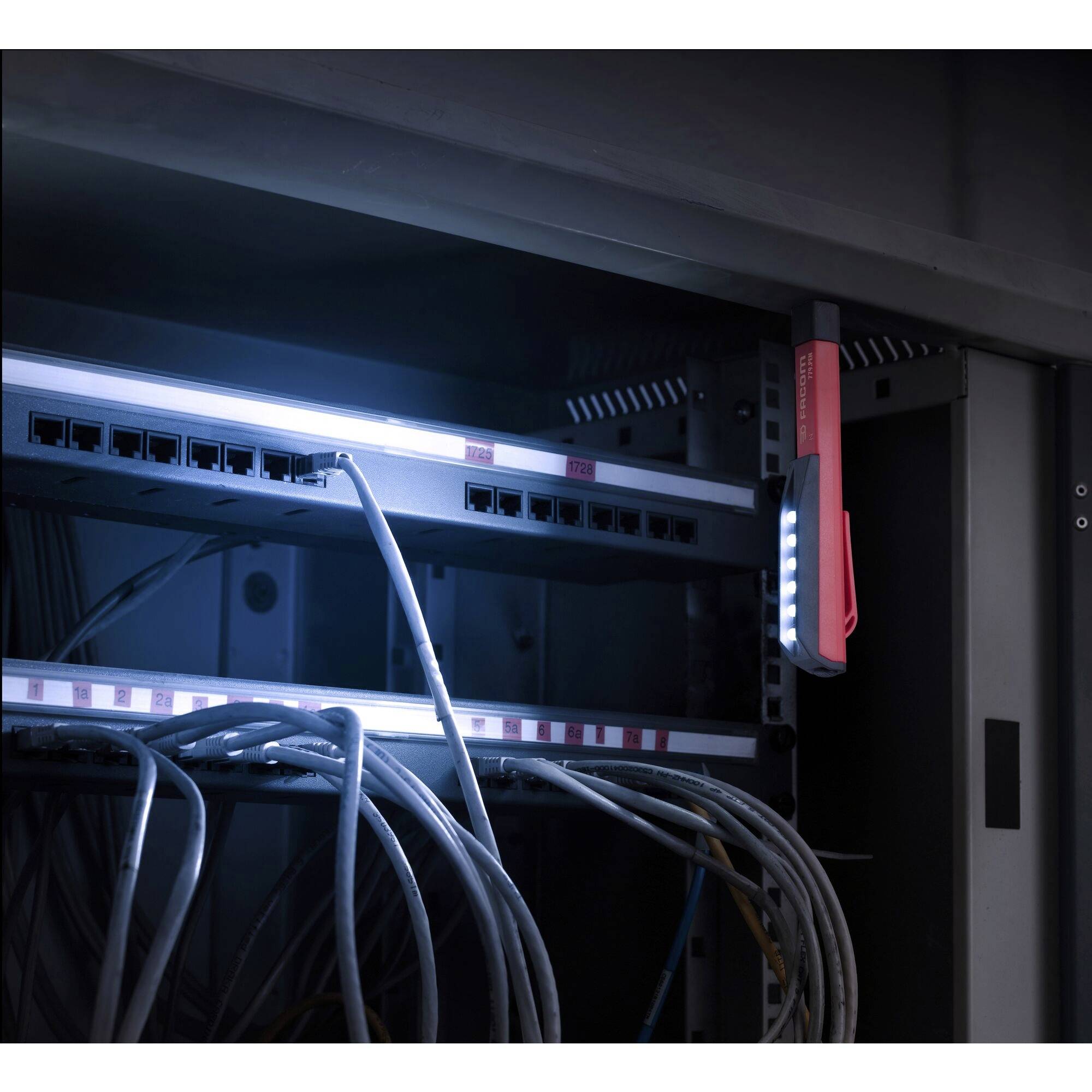 A illuminated server cabinet with network cables and an attached inspection light.