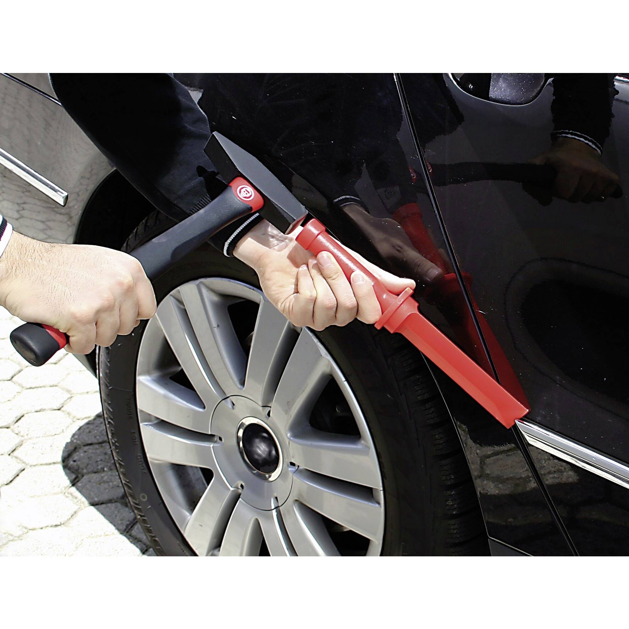 'A person is using a red lockpicking tool to break into a car's door lock.'
