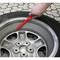 A hand points with a red marker to the edge of a damaged car tyre on a cobblestone surface.