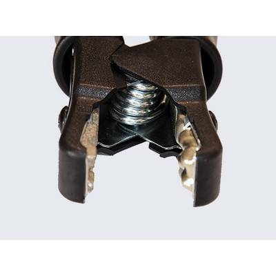 Close-up of a black alligator clip with visible metal teeth and spring, used for connecting to batteries or electrical components.