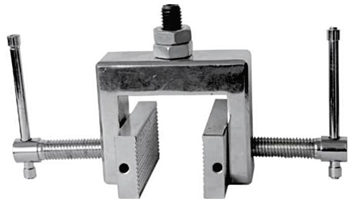 Metal clamp device with two securing screws, suitable for precisely holding workpieces during machining.