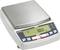 A digital kitchen scale displays '0.00 g' on an LCD screen. The scale is made of silver-coloured metal and has control buttons underneath.