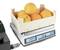 A wooden crate of oranges is sitting on a digital scale. The scale displays a weight of 2,524 grams.