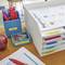 Organised workspace with a filing tray set; labels reading 'To Be Filed', 'Graded Papers', 'Exams'; red pens, paperclips.