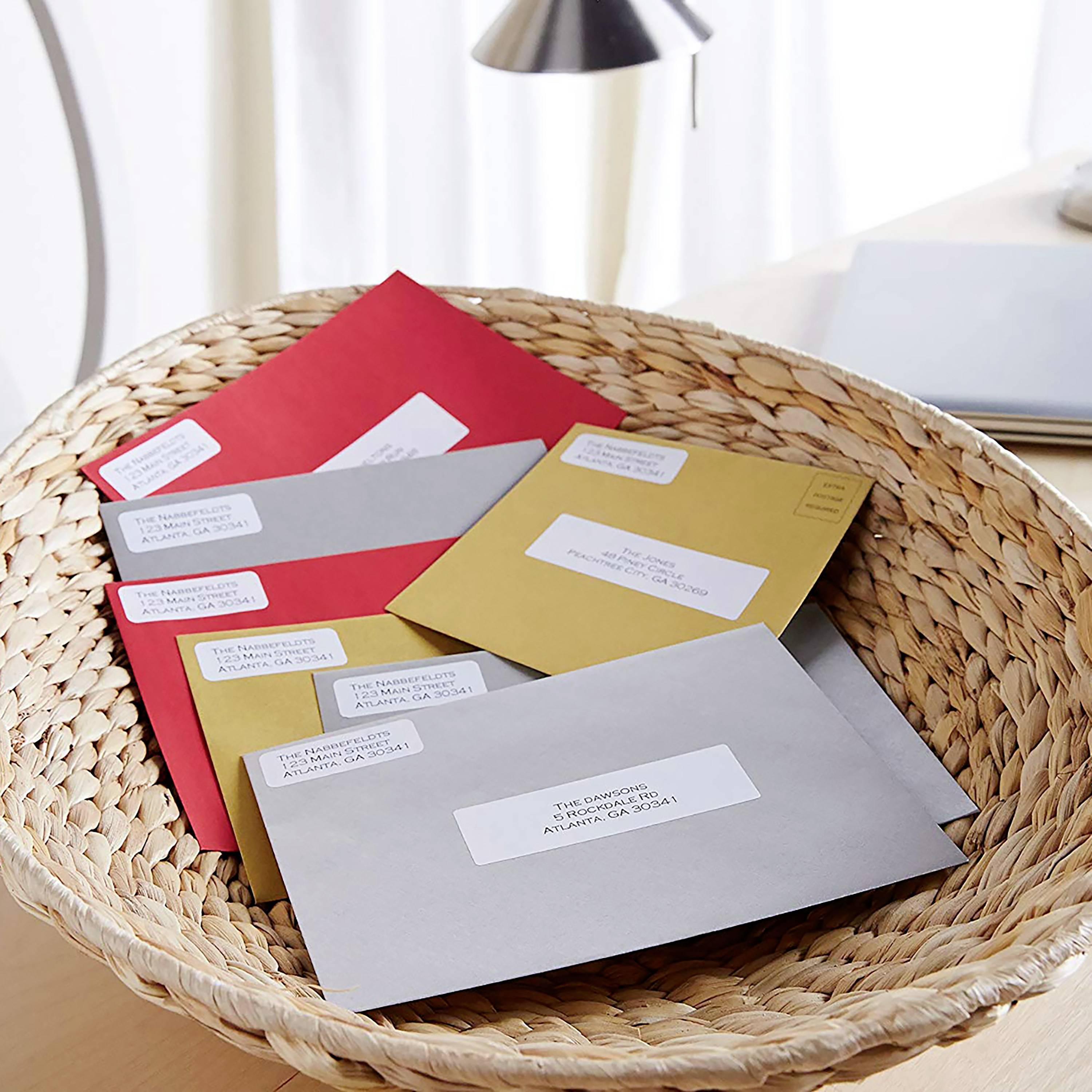 A woven basket on a table, filled with several letters in envelopes of various colours, partially visible.