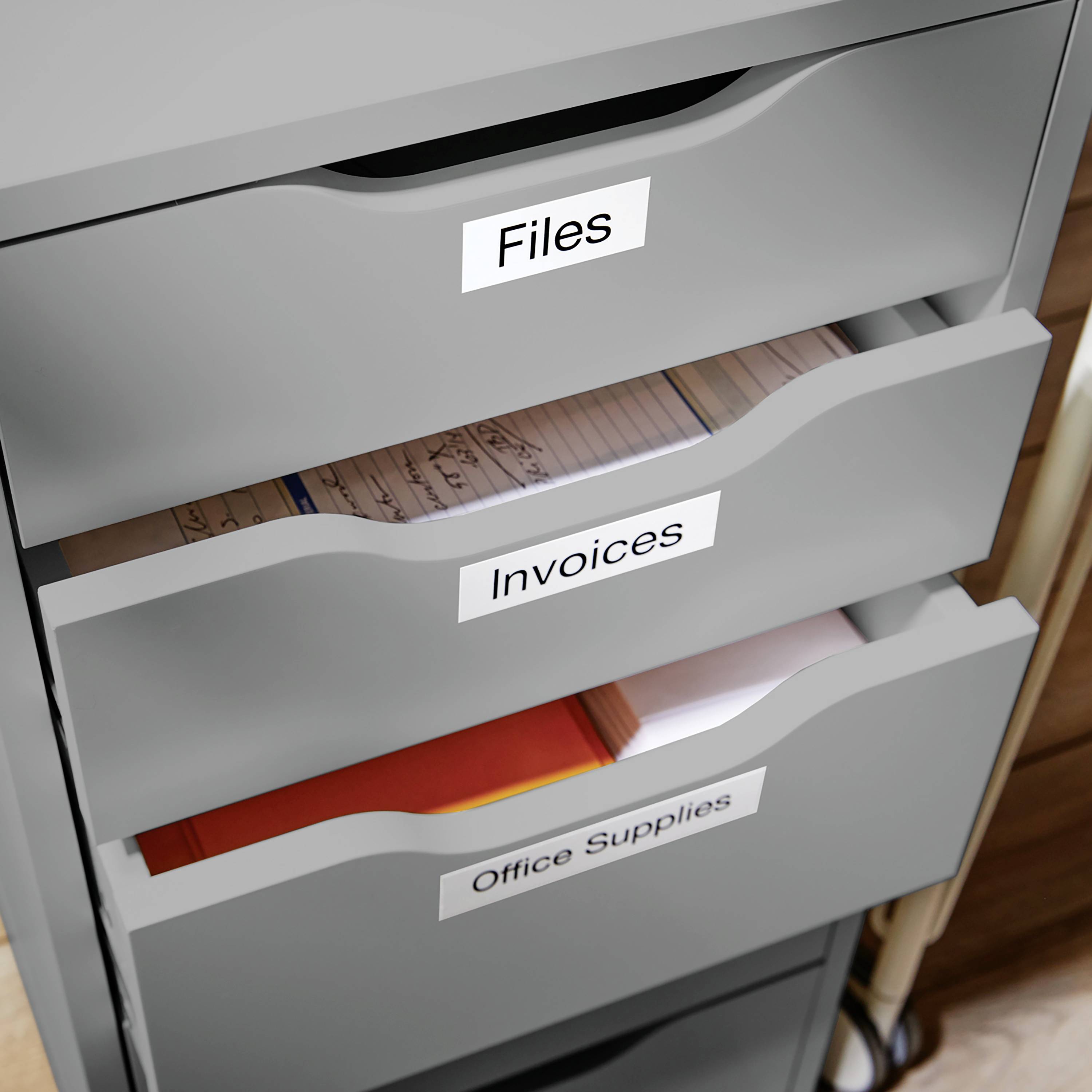 Grey filing cabinet with three drawers, labelled 'Files', 'Invoices' and 'Office Supplies'.