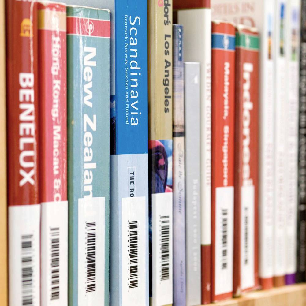 A library shelf row with travel guides for various countries and regions, including Benelux, New Zealand, and Scandinavia.