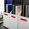 Filing drawer with labels 'Travel', 'Home', 'Insurance', filled with folders and notebooks, on an office desk.