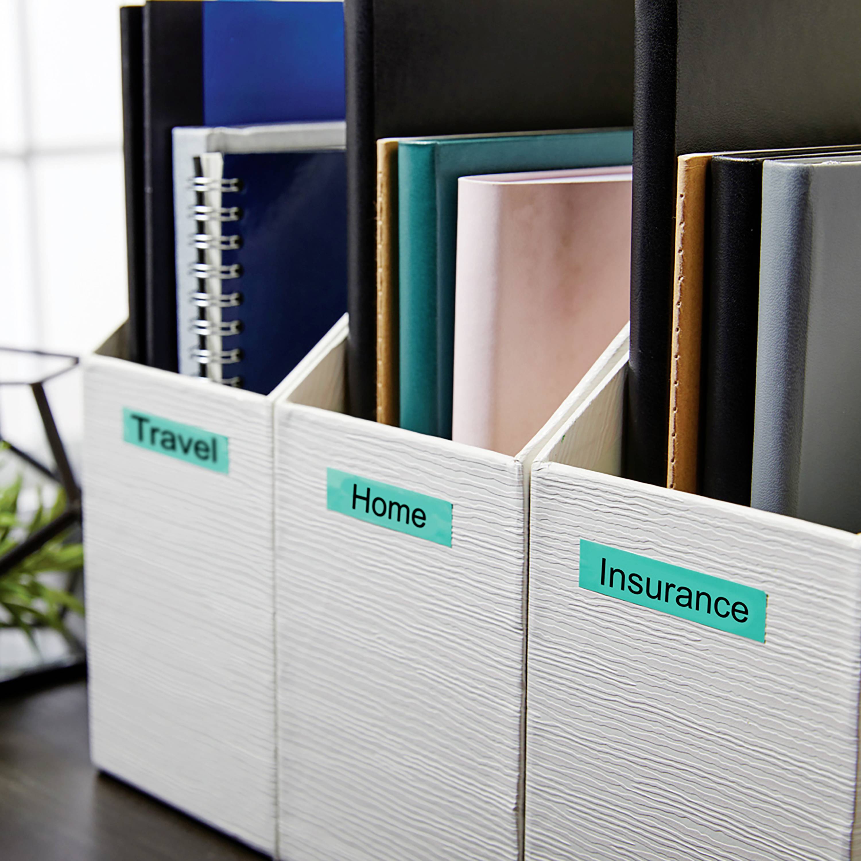 Three white storage boxes labelled 'Travel', 'Home' and 'Insurance', filled with folders and notebooks, are placed side by side.