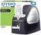 Dymo LabelWriter 450 Duo label printer prints the text 'Peter Smith, Visitor, Location: Conference Room' on a label.