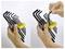 'Hands holding a set of black Allen wrenches in a yellow holder, with one wrench being removed.'