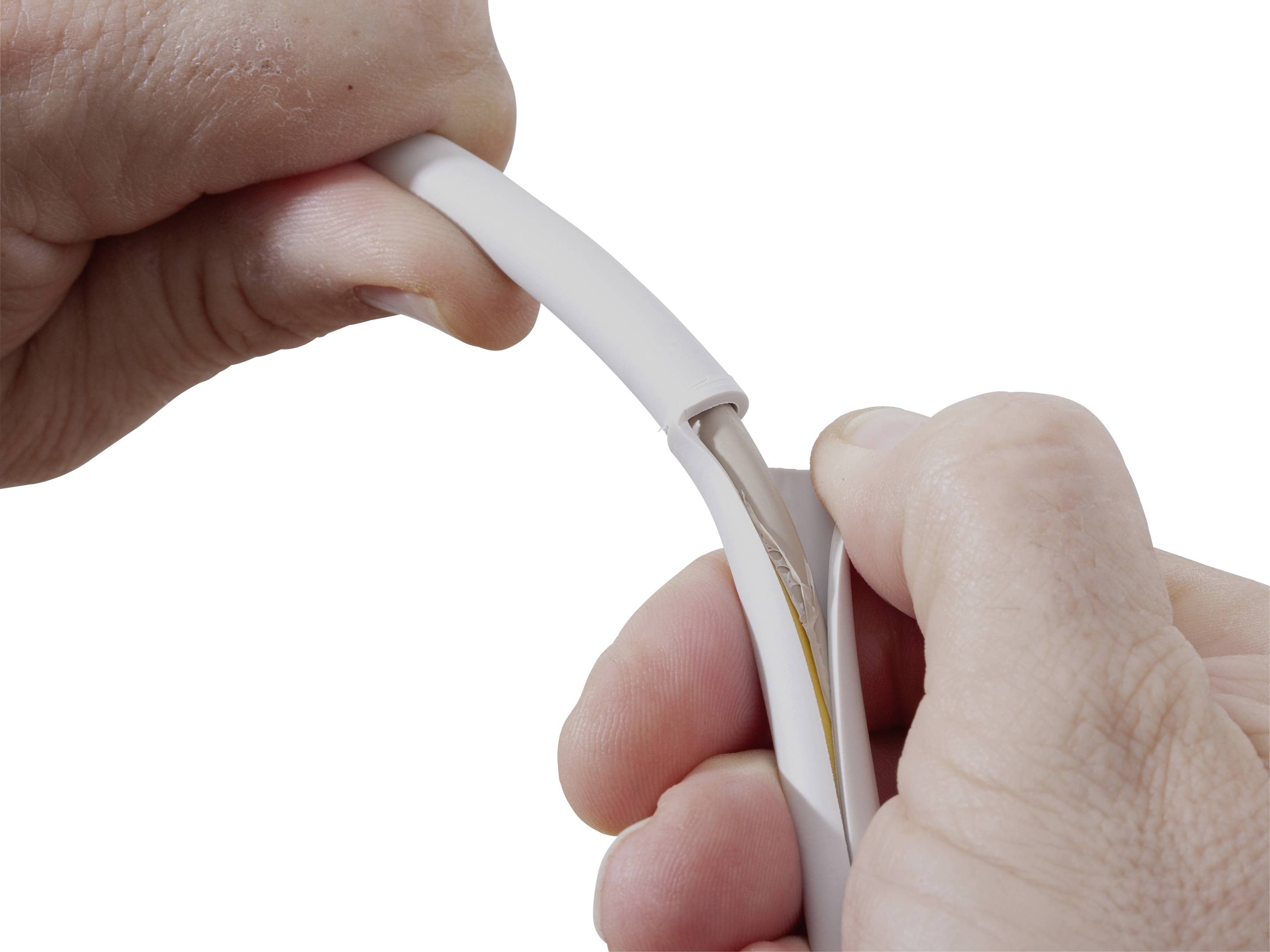Hands demonstrating how to open a cable sheath to expose the inner workings of a cable.