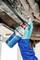 A person wearing gloves sprays undercarriage protection on the underside of a vehicle to prevent rust and corrosion, ensuring durability.