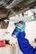 A person in protective gloves sprays undercarriage coating on a car's underside, highlighting vehicle maintenance.