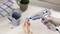 A person is repairing a broken cup using a hot glue gun. Two additional cups and a towel are in the background.