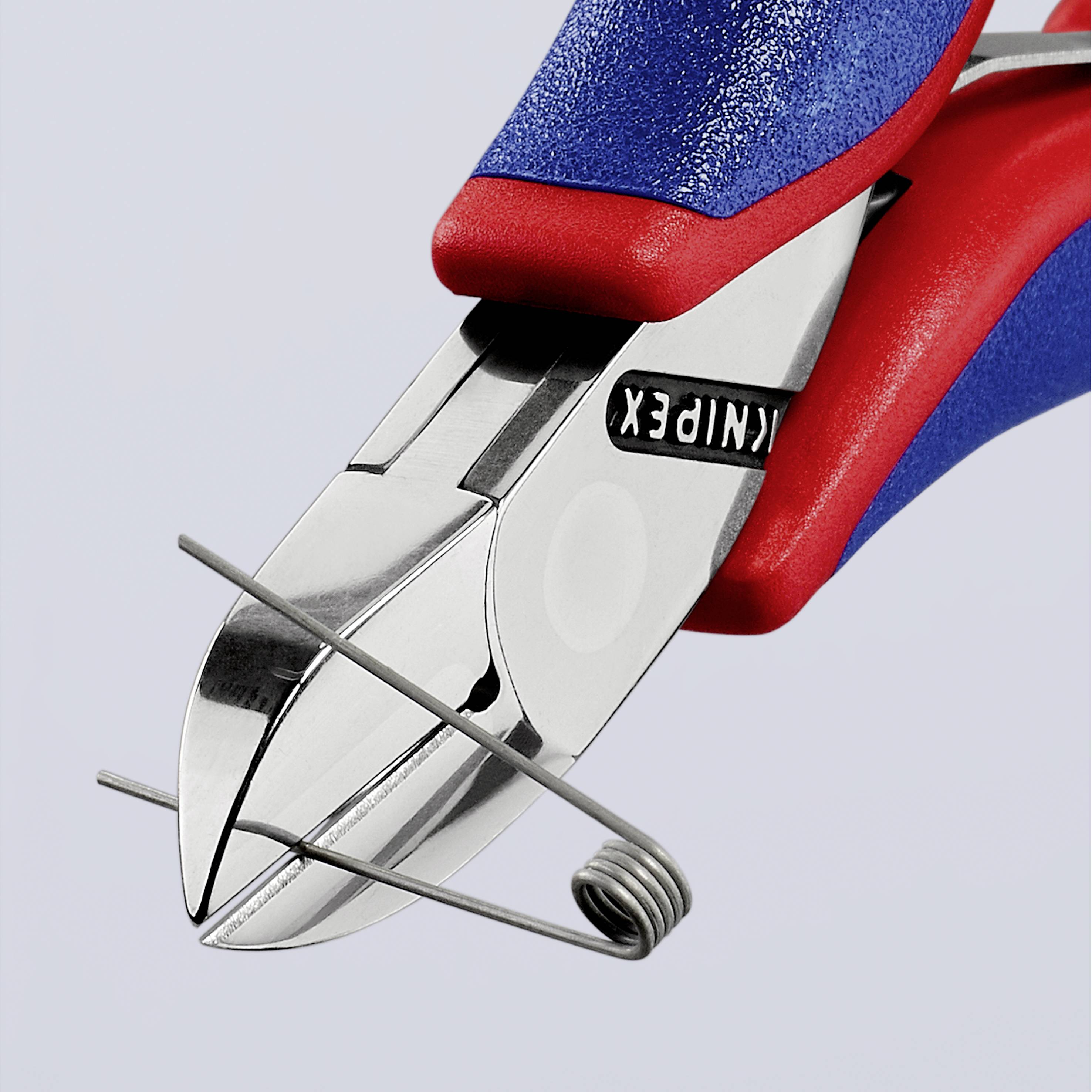 Pliers with red and blue handles precisely cut a wire.