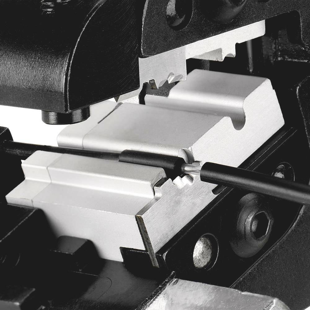 Close-up of a metal device with cables and precise machine components, likely related to manufacturing processes.