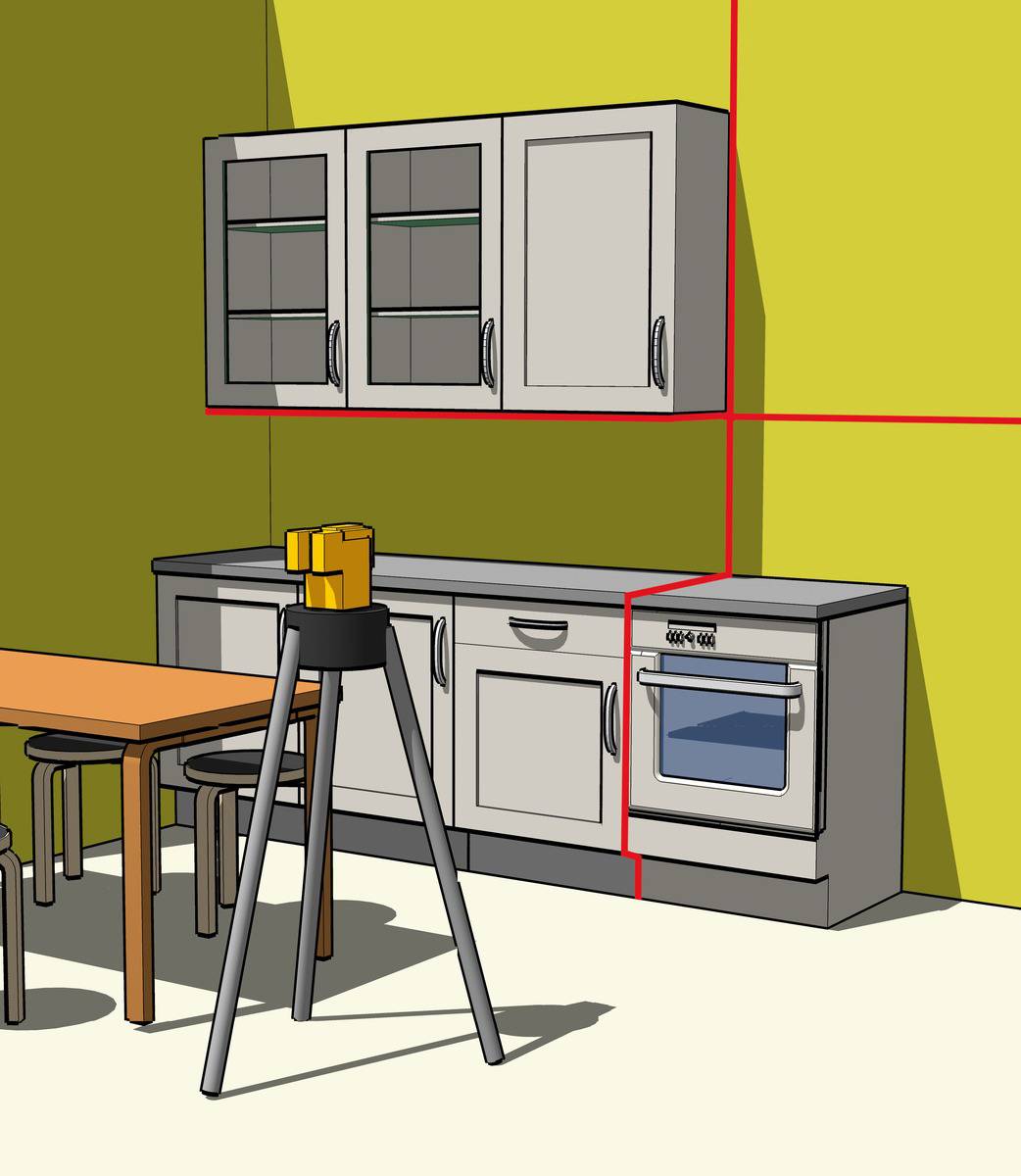 A kitchen with yellow walls. In the foreground, a laser level mounted on a tripod, indicating whether walls and cabinets are level.