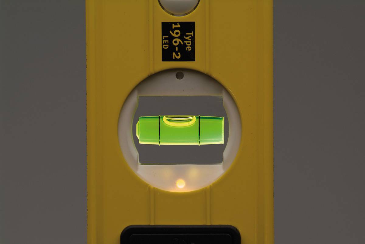 Spirit level with a green bubble indicator centred in the viewing window, signalling horizontal alignment.
