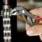 A hand is using a black water pump pliers to tighten a screw nut on a mechanical component.