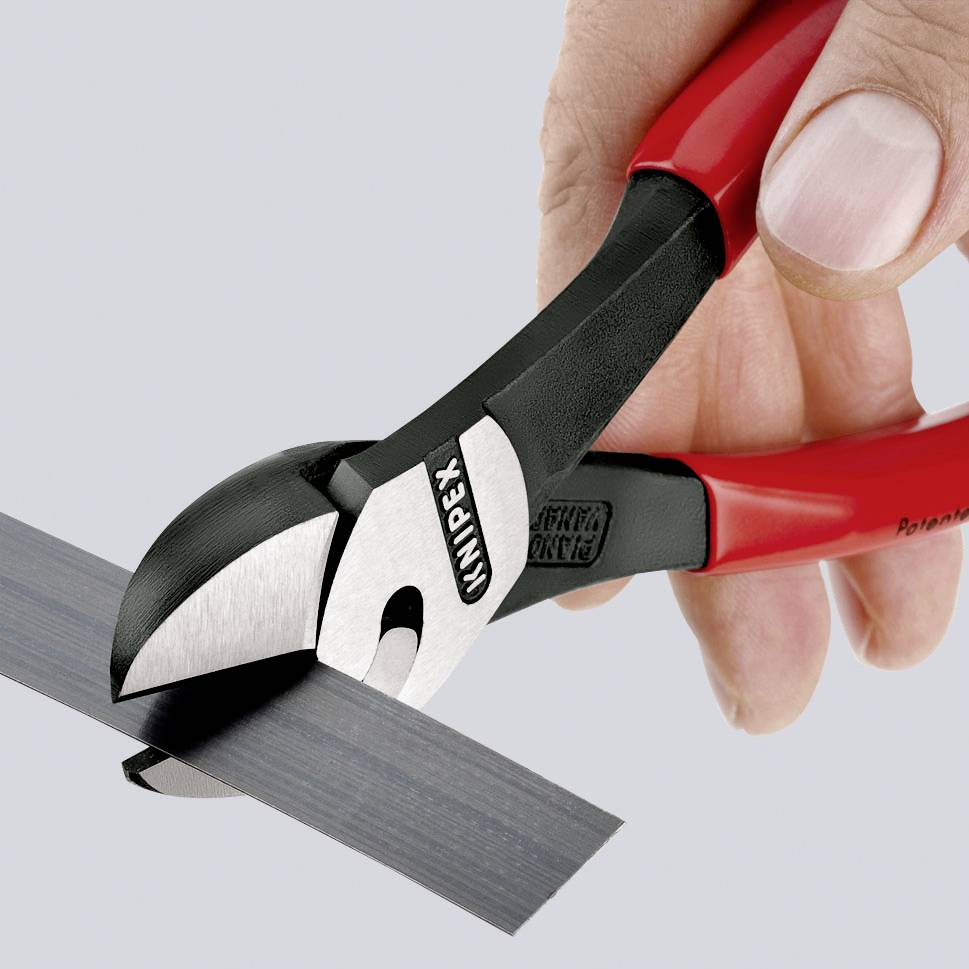 Red pliers cutting black cable. Hand holding tool. Brand name visible on pliers. Used in electrical work.